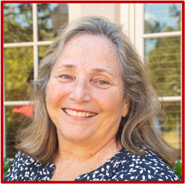 A smiling woman with shoulder-length salt and pepper hair.